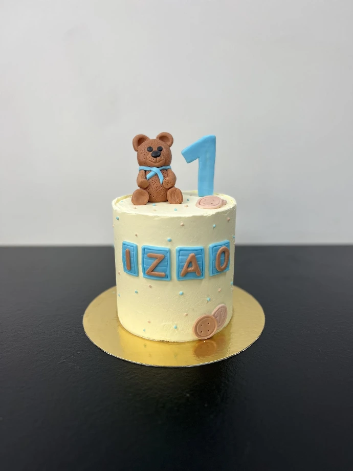 Gâteau d’anniversaire bleu personnalisé avec décoration de petit ourson.