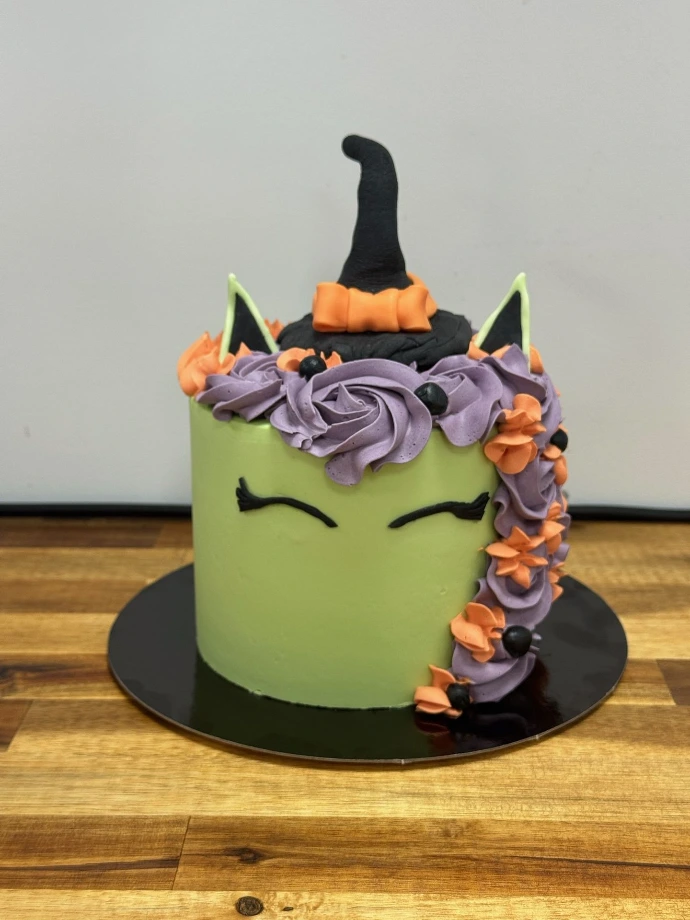 Gâteau d’Halloween personnalisé vert et violet avec décoration de sorcière.