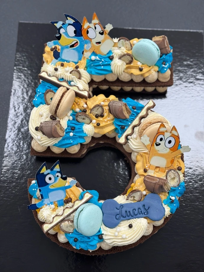 Gâteau chiffre 5 personnalisé bleu et doré avec décorations gourmandes.