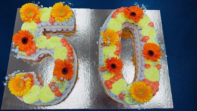 Gâteau chiffre 50 personnalisé orange et jaune avec des fleurs..