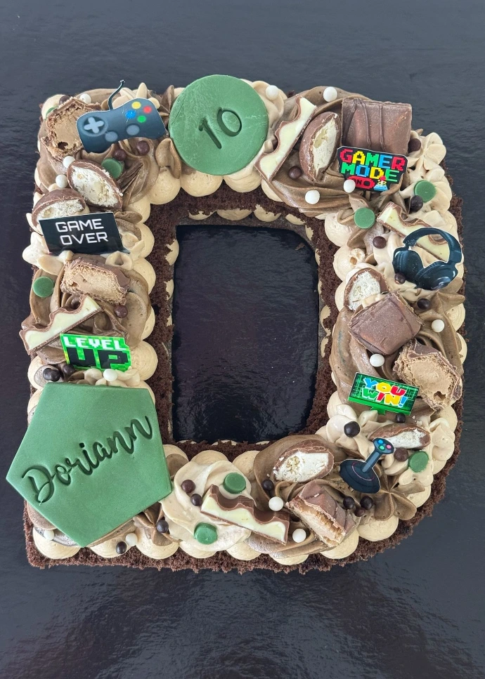 Gâteau lettre D personnalisé décoré de vert et marron.