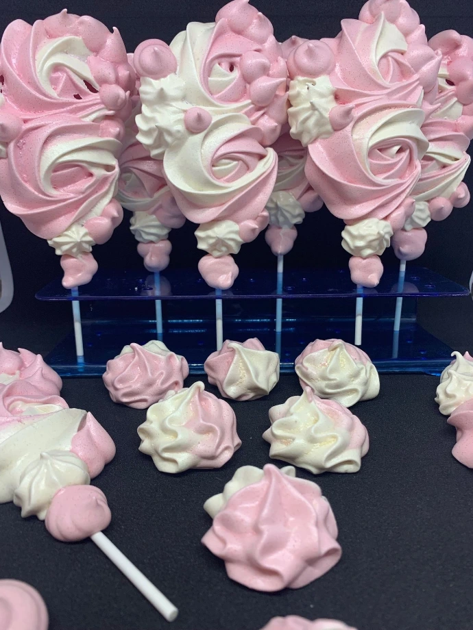 Meringues et douceurs roses sur bâtonnets.