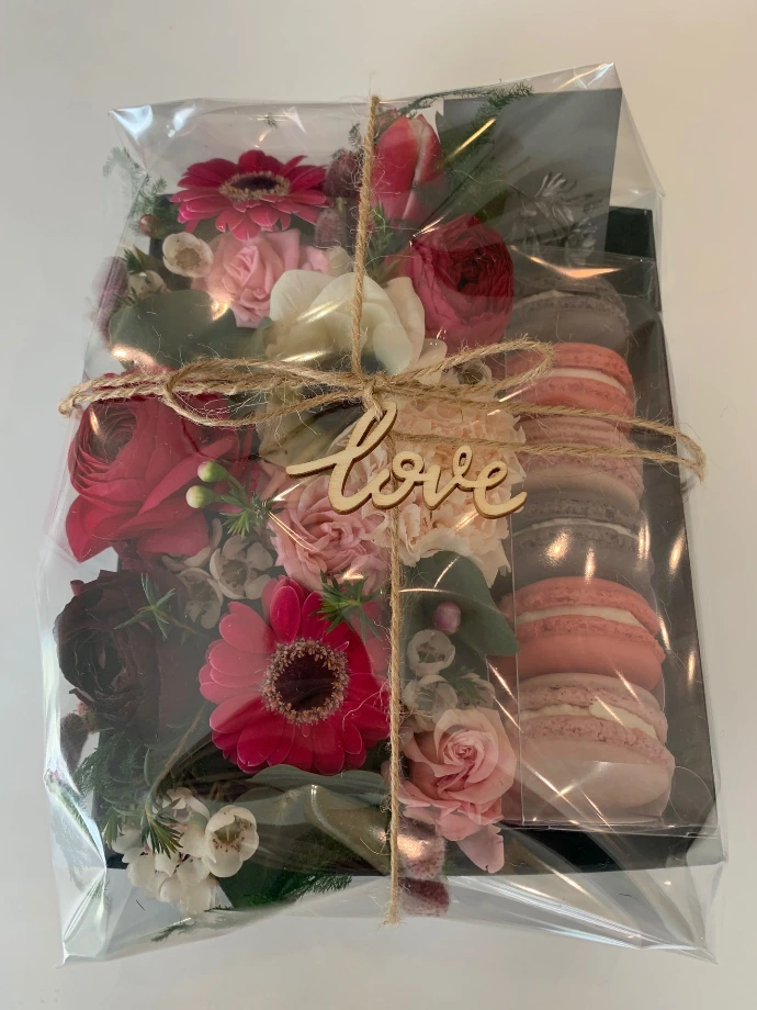 Coffret gourmand personnalisé avec macarons et fleurs.